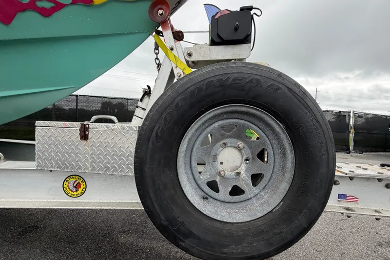 Slide: The Image of Trailer wheel of a 2011 Apache 28 Splash boat, featuring Goodyear tire and metal frame. - 105