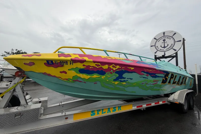 Slide: The Image of Colorful 2011 Apache 28 Splash boat on trailer, vibrant design, overcast sky. - 1