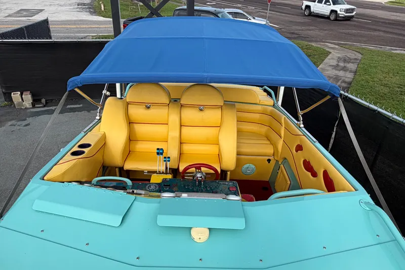 Slide: The Image of Colorful 2011 Apache 28 Splash boat with yellow seats and blue canopy. - 76