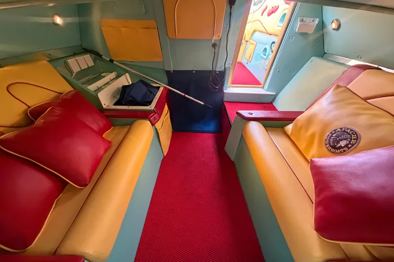 Slide: The Image of Interior of a 2011 Apache 28 Splash boat with vibrant red and yellow seating. - 55