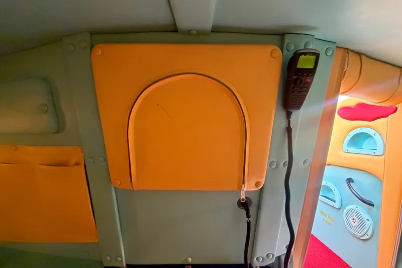 Slide: The Image of Interior of a 2011 Apache 28 Splash boat, featuring vibrant upholstery and communication equipment. - 65
