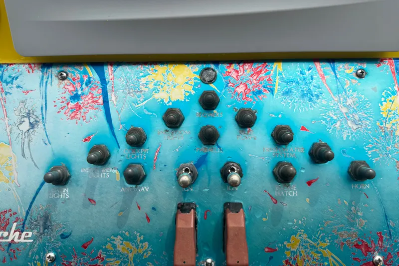 Slide: The Image of Colorful control panel of a 2011 Apache 28 Splash boat with various switches. - 35