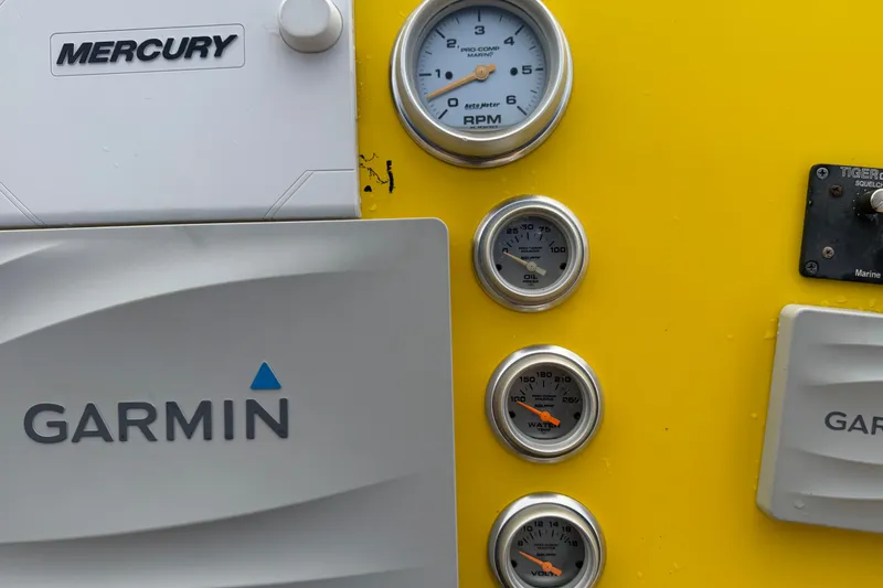 Slide: The Image of Control panel of a 2011 Apache 28 Splash boat with Garmin and Mercury devices. - 28