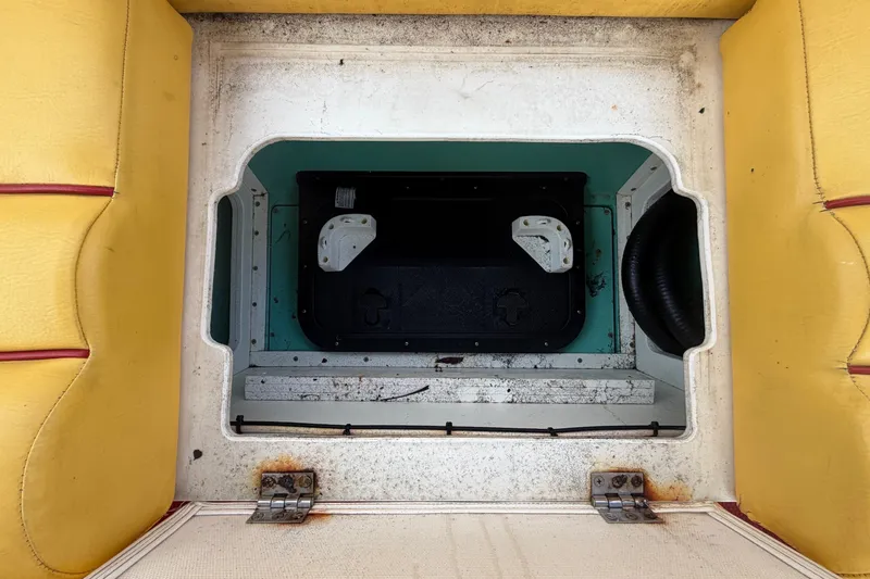 Slide: The Image of Open storage compartment in 2011 Apache 28 Splash boat with yellow seating. - 89