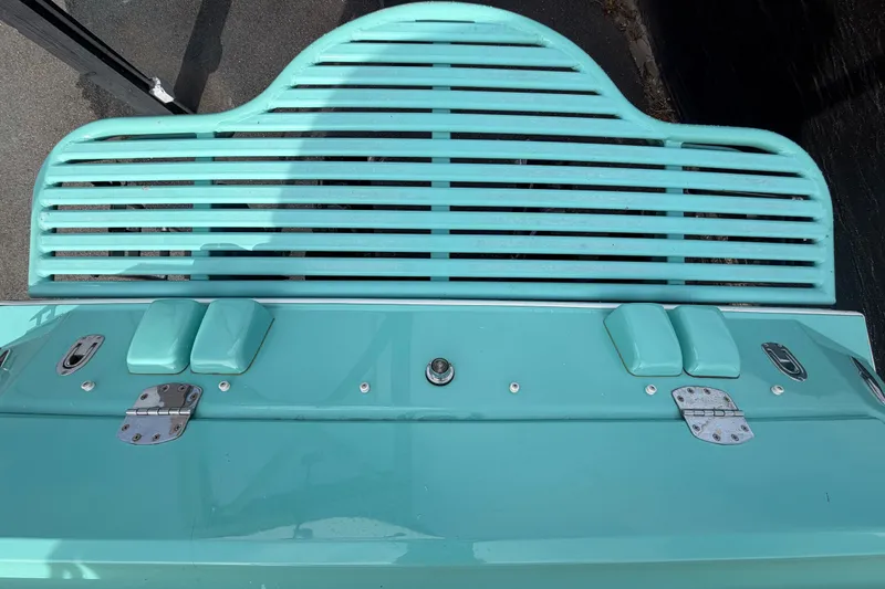 Slide: The Image of Turquoise deck of a 2011 Apache 28 Splash boat with metal fittings and slatted design. - 100