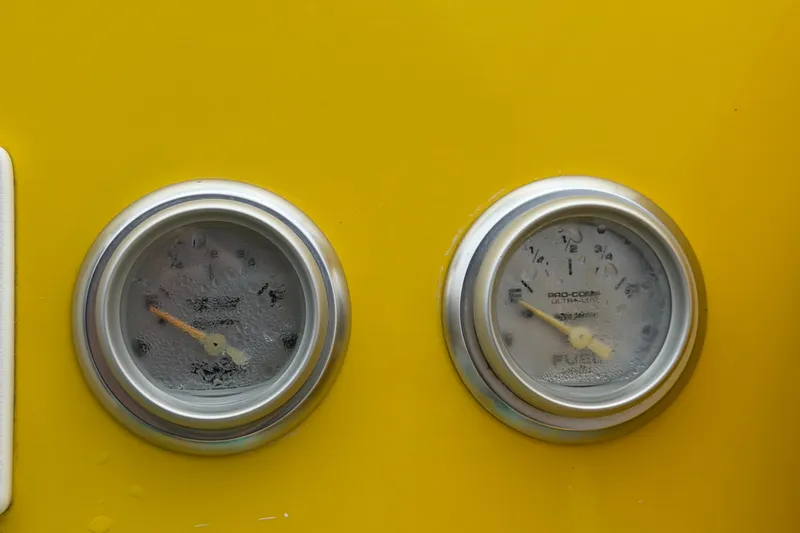 Slide: The Image of Close-up of gauges on a yellow 2011 Apache 28 Splash boat dashboard. - 33