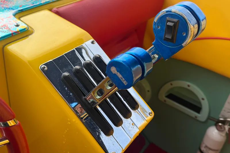 Slide: The Image of Colorful control panel of a 2011 Apache 28 Splash boat with throttle levers. - 38