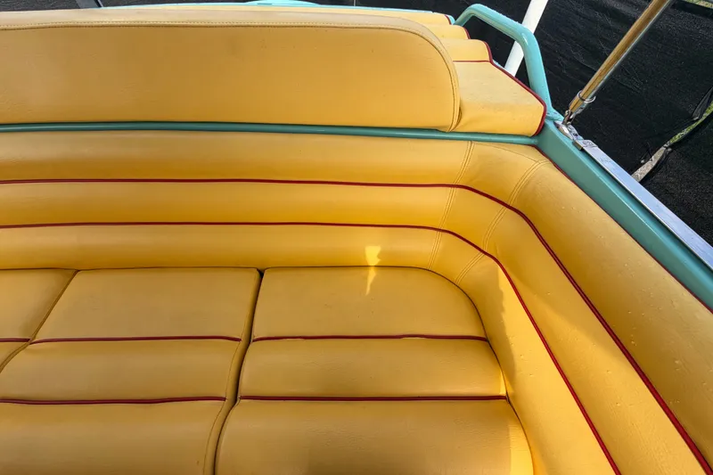 Slide: The Image of Yellow and teal seating on a 2011 Apache 28 Splash boat, featuring red accents. - 85