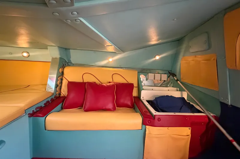 Slide: The Image of Interior of 2011 Apache 28 Splash boat with colorful seating and storage compartments. - 56