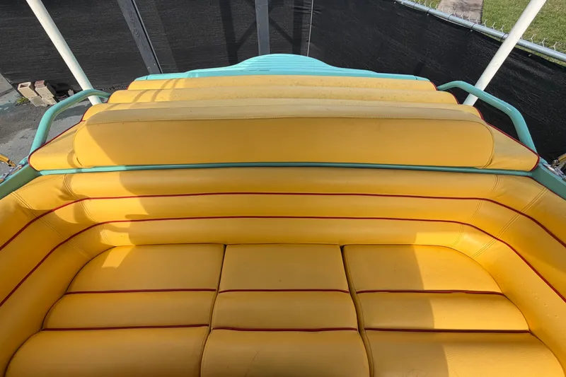 Slide: The Image of Yellow seating on a 2011 Apache 28 Splash boat, featuring red accents and teal trim. - 84