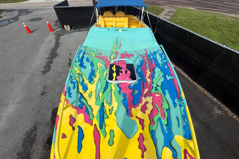 Slide: The Image of Colorful 2011 Apache 28 Splash boat with vibrant abstract design and blue canopy. - 75