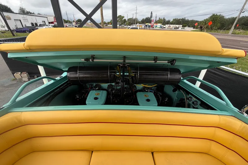Slide: The Image of Engine compartment of a 2011 Apache 28 Splash boat with yellow seating and teal accents. - 95