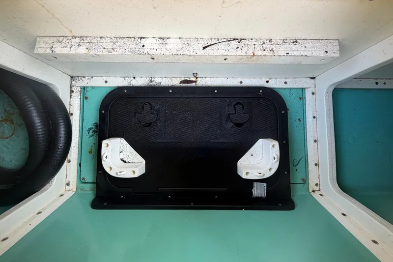 Slide: The Image of Interior view of a 2011 Apache 28 Splash boat compartment with wiring and hatch. - 90