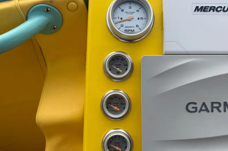 Slide: The Image of Dashboard of a 2011 Apache 28 Splash boat with gauges and Garmin equipment. - 25