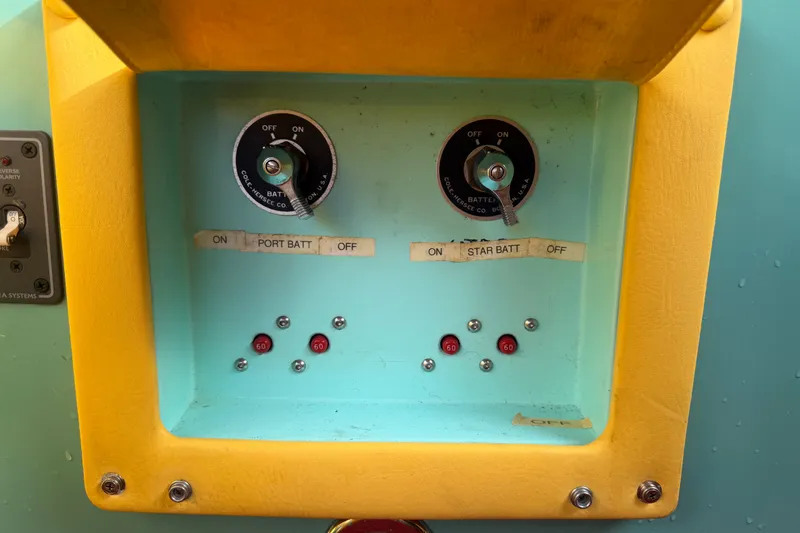 Slide: The Image of Control panel of a 2011 Apache 28 Splash boat with battery switches and indicators. - 82