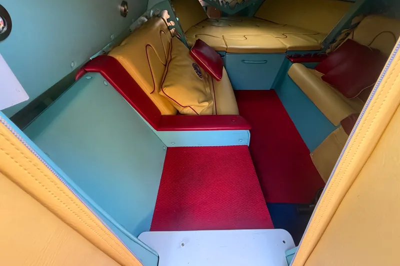 Slide: The Image of Interior of a 2011 Apache 28 Splash boat with colorful seating and red carpet. - 43