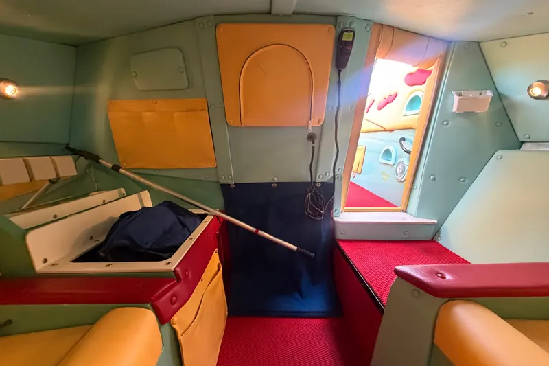Slide: The Image of Colorful interior of a 2011 Apache 28 Splash boat, featuring vibrant seating and storage compartments. - 64