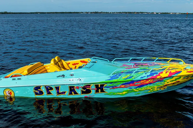 The Image of Colorful 2011 Apache 28 Splash speedboat on open water, vibrant design and yellow seats. - 1