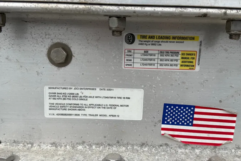 Slide: The Image of Label on Apache 28 Splash 2011 trailer with tire and loading information, featuring an American flag sticker. - 102