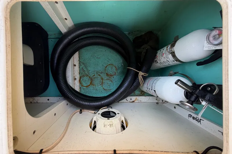 Slide: The Image of Interior view of a 2011 Apache 28 Splash boat compartment with hoses and equipment. - 87