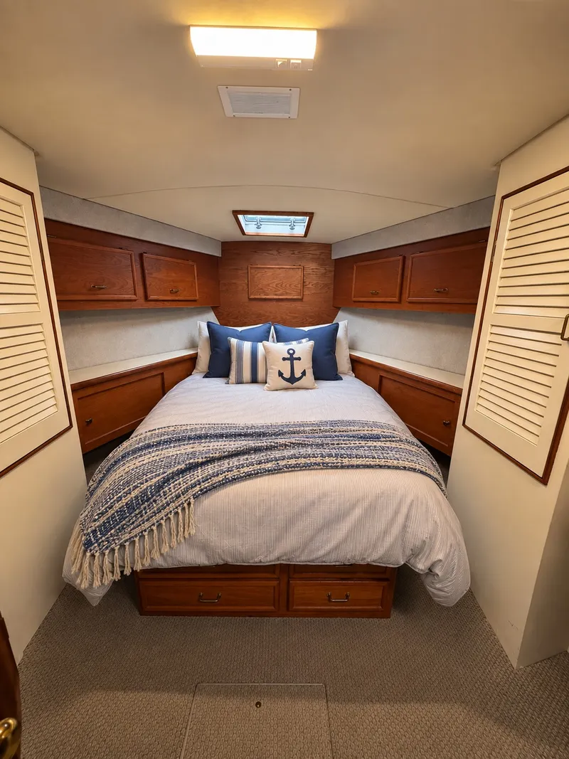 Slide: The Image of The image shows a cozy cabin with a double bed, surrounded by wooden cabinetry and storage. - 49