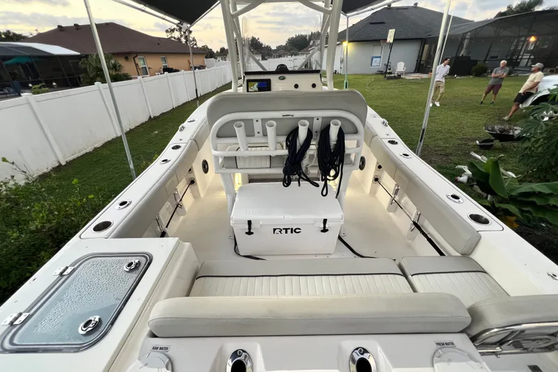 Slide: The Image of 2024 Sea Fox 228 Commander boat interior with seating, cooler, and rod holders. - 13