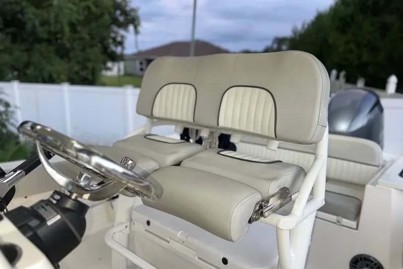 Slide: The Image of 2024 Sea Fox 228 Commander boat helm with dual cushioned seats and steering wheel. - 37