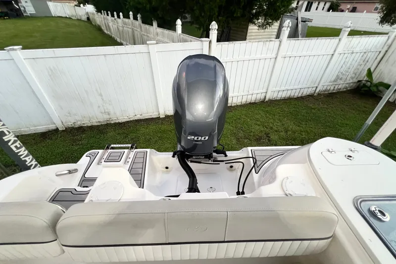 Slide: The Image of 2024 Sea Fox 228 Commander boat with powerful 200 horsepower engine, parked near white fence. - 17