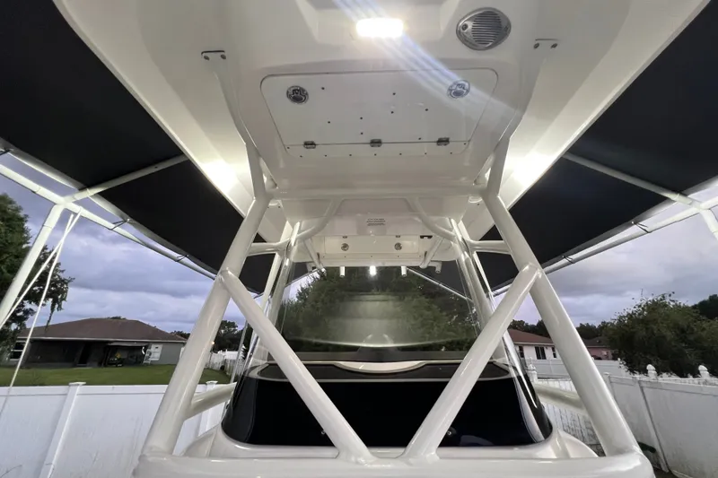 Slide: The Image of 2024 Sea Fox 228 Commander boat with T-top and lighting, docked in a residential area. - 53
