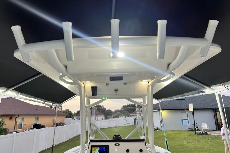 Slide: The Image of 2024 Sea Fox 228 Commander boat with T-top and rod holders in a residential backyard. - 11