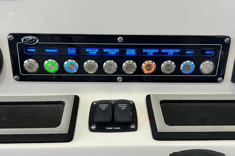 Slide: The Image of Control panel of 2024 Sea Fox 228 Commander boat with labeled switches and trim tabs. - 47