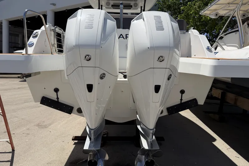 Slide: The Image of 2022 Jeanneau Leader 9.0 CC boat with dual outboard engines, docked outdoors. - 32
