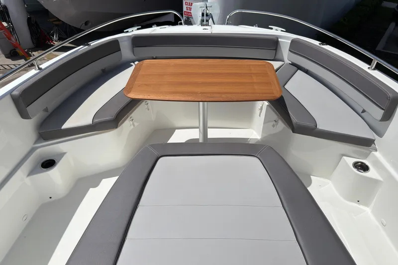 Slide: The Image of 2022 Jeanneau Leader 9.0 CC boat interior with seating and wooden table. - 26