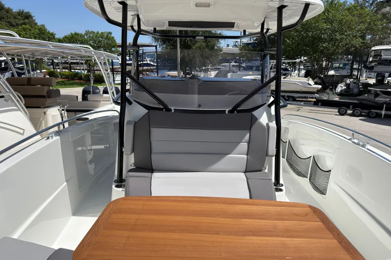 Slide: The Image of 2022 Jeanneau Leader 9.0 CC boat interior with seating and wooden table. - 28
