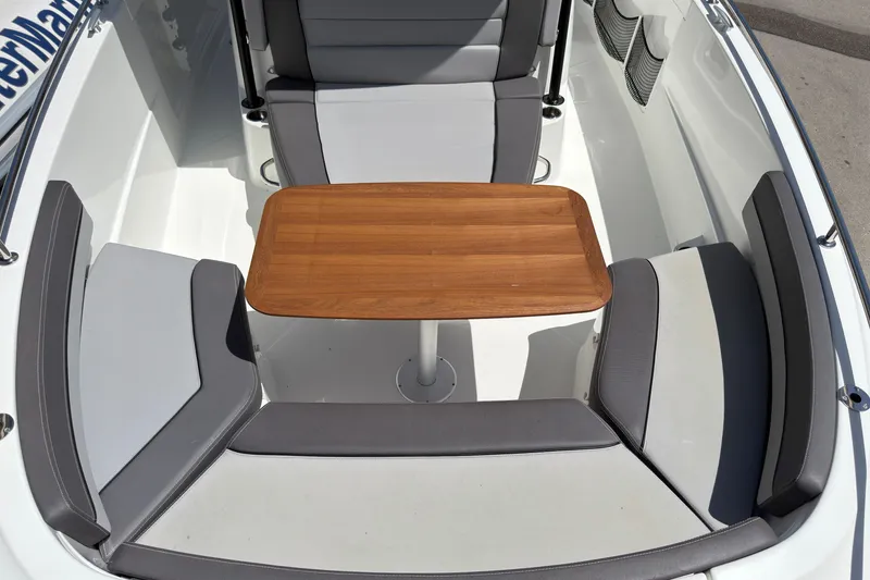 Slide: The Image of 2022 Jeanneau Leader 9.0 CC boat interior with cushioned seating and wooden table. - 27