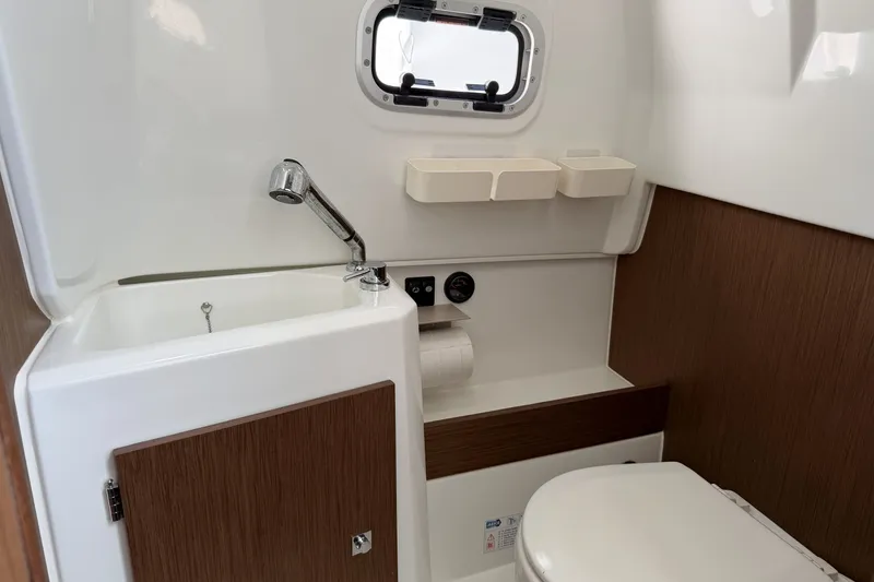 Slide: The Image of 2022 Jeanneau Leader 9.0 CC boat bathroom with sink, toilet, and storage. - 19