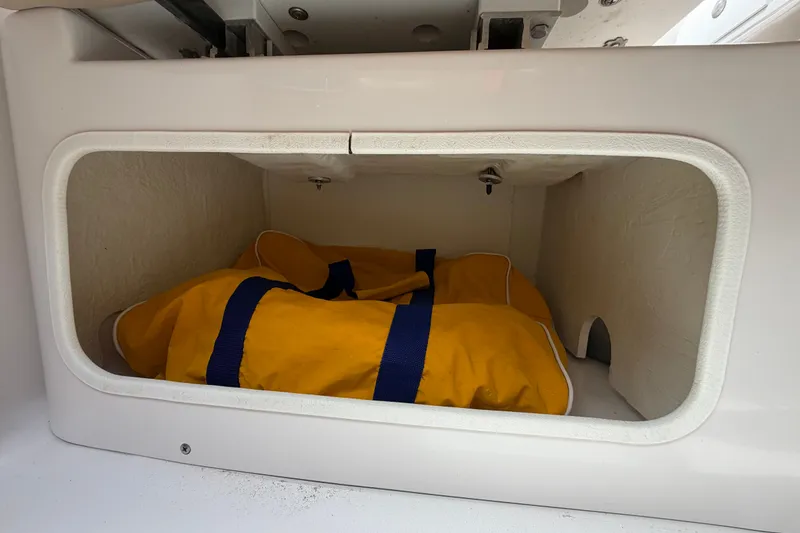 Slide: The Image of Storage compartment in a 2011 Four Winns V285 boat with a yellow bag inside. - 104