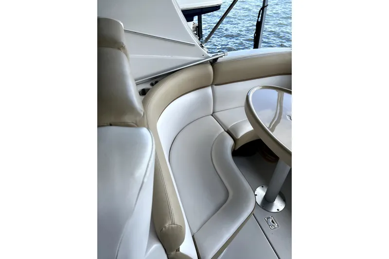 Slide: The Image of 2011 Four Winns V285 boat interior with beige seating and table by the water. - 8