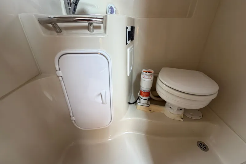 Slide: The Image of 2011 Four Winns V285 boat bathroom with toilet and storage compartment. - 85