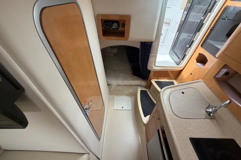 Slide: The Image of Interior of 2011 Four Winns V285 boat, featuring kitchenette and cozy sleeping area. - 82