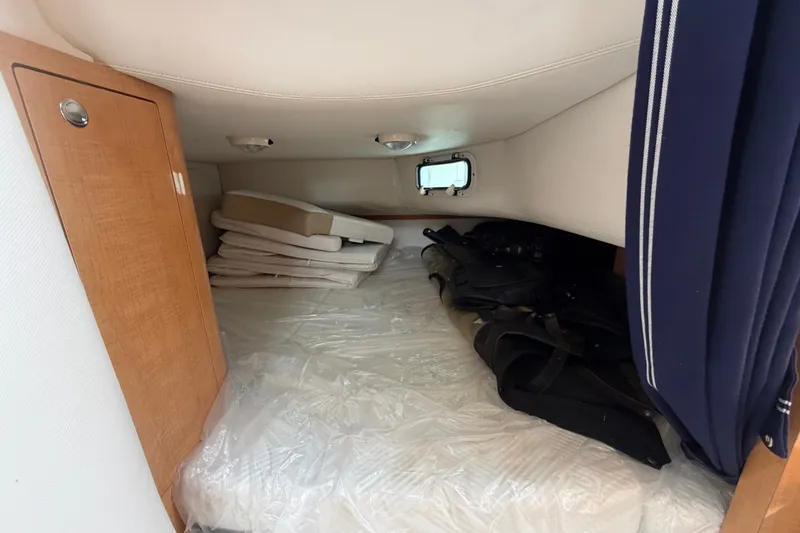Slide: The Image of 2011 Four Winns V285 cabin interior with storage and cushions. - 93