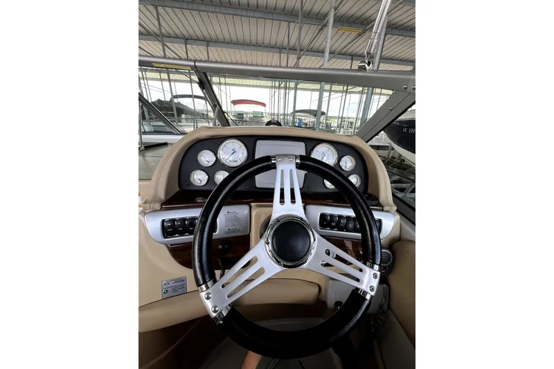 Slide: The Image of Steering wheel and dashboard of 2011 Four Winns V285 boat in a marina setting. - 7