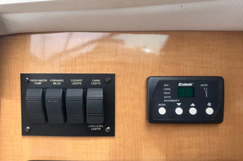 Slide: The Image of Control panel of a 2011 Four Winns V285 boat with switches and climate controls. - 49