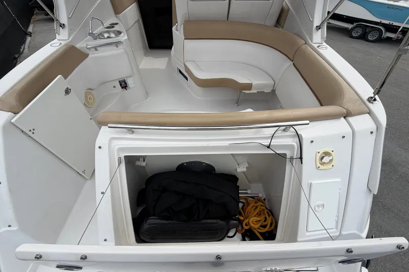 Slide: The Image of 2011 Four Winns V285 boat interior with seating, storage, and sink. - 5