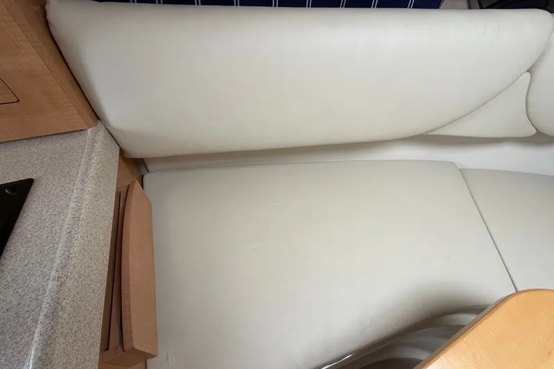 Slide: The Image of Interior seating of 2011 Four Winns V285 boat with beige upholstery and wooden cabinetry. - 70
