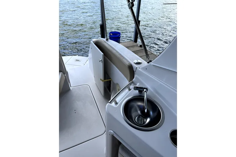 Slide: The Image of 2011 Four Winns V285 boat interior with sink, docked by the water. - 11