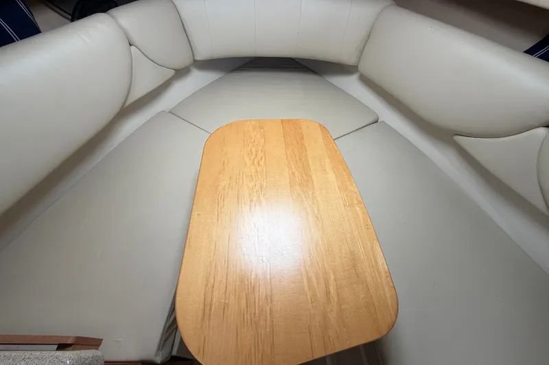 Slide: The Image of Interior of 2011 Four Winns V285 boat with wooden table and cushioned seating. - 69