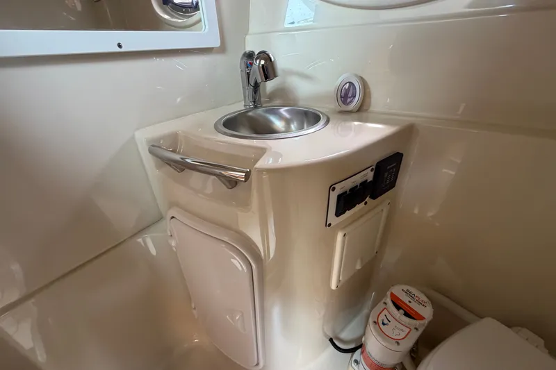 Slide: The Image of 2011 Four Winns V285 boat bathroom with sink, faucet, and storage compartment. - 86
