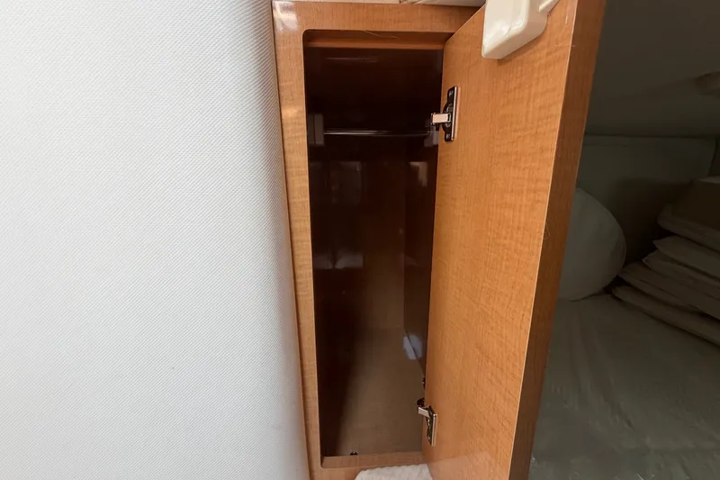 Slide: The Image of Open wooden cabinet inside 2011 Four Winns V285 boat, showcasing interior storage space. - 95
