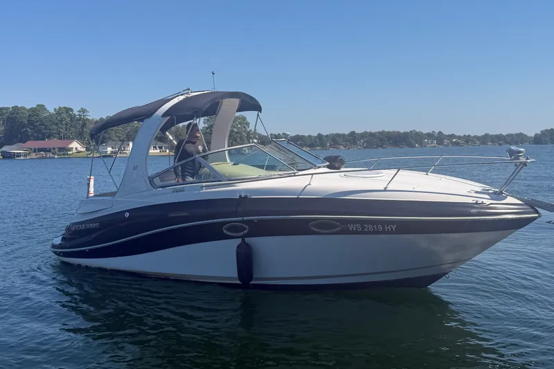 The Image of 2011 Four Winns V285 boat on a calm lake under clear blue skies. - 0